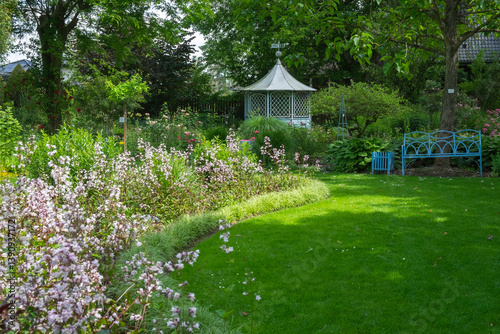 Staudenbeete, blaue Gartenbank und Pavillon