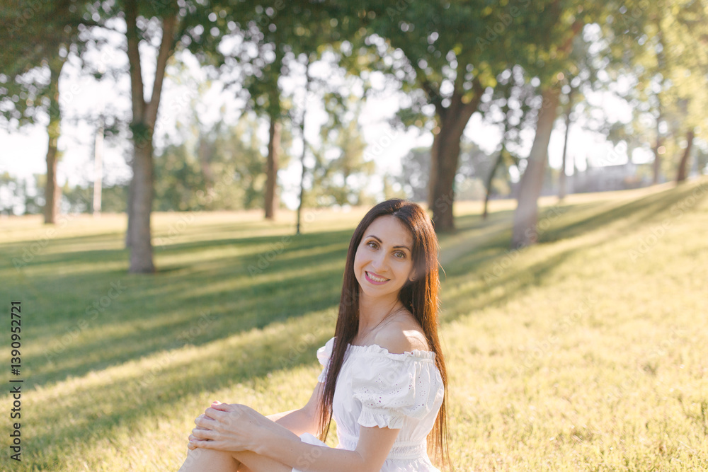 A young beautiful woman is sitting outdoor on a sunny morning. Relax in nature, happiness. Enjoying Summer days outdoors A young beautiful woman is sitting outdoor on a sunny morning. Relax in nature, happiness. Enjoying Summer days outdoors
