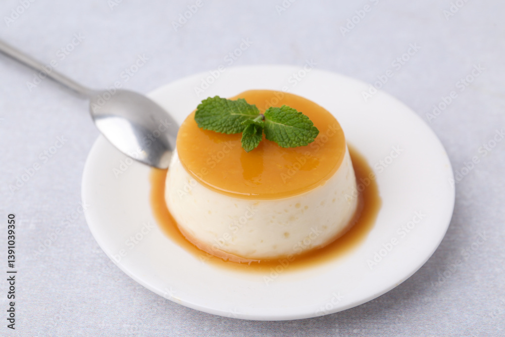 Tasty pudding with caramel sauce served on white table, closeup Tasty pudding with caramel sauce served on white table, closeup