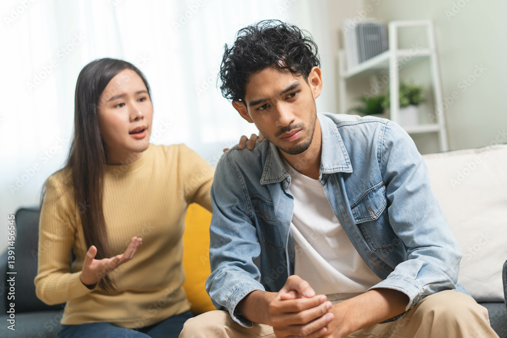 Obraz premium Family problem concept. Tension in relationship between married couple, husband and wife staying sitting separate after quarrel in the living room.