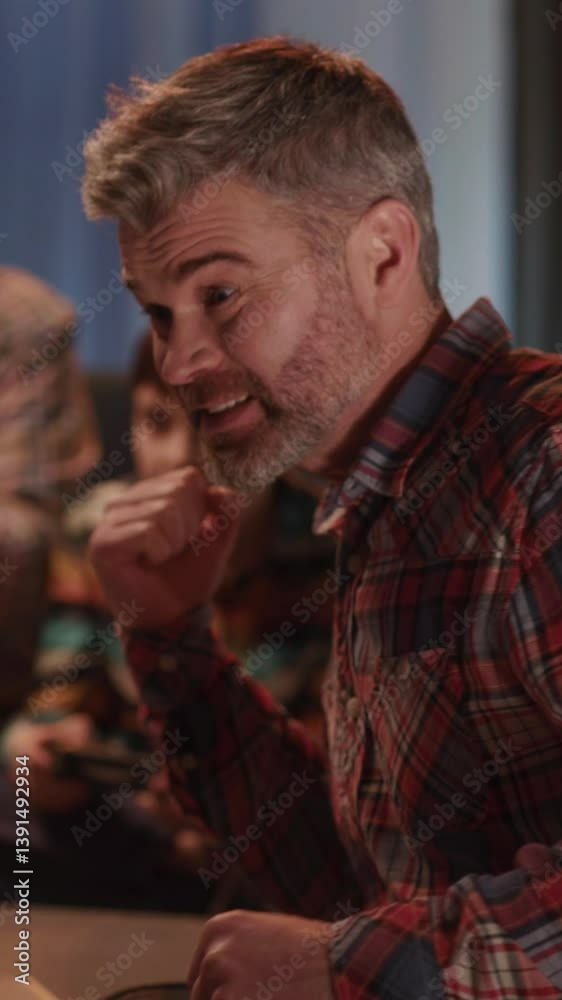 Father cheering up for his son playing computer console game with grandparent in living room. Concept for team, support and friendship. Entertainment.