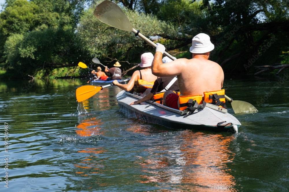 Family with children on rafting trip in Group kayak trip of different ages, adults, elderly. Rowing boat on the river, a water hike, summer adventure.