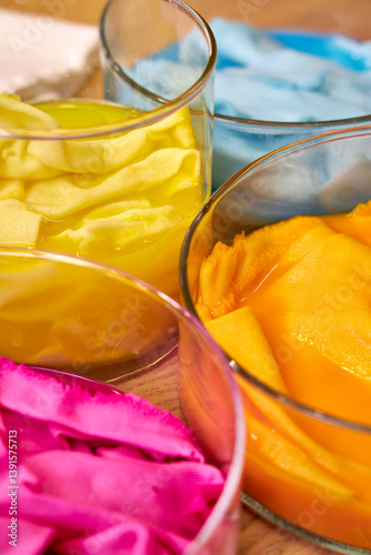 top view of glass flasks with dyed bright fabrics, background for needlework