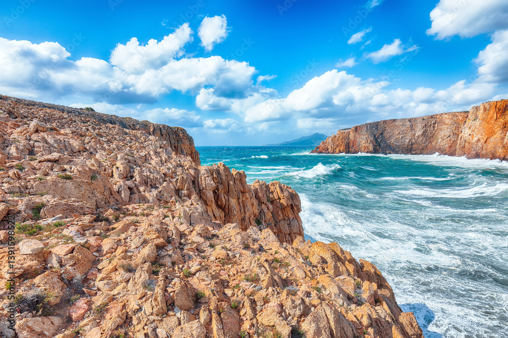 Attractive view of cliffs in valley Cala Domestica and storm on the sea