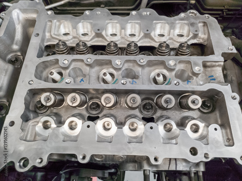 The petrol engine is being overhauled, the camshaft and spark plug assembly can be seen