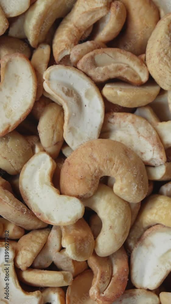 Roasted cashew nuts cracking close-up. Crispy texture and warm beige tones. 4k vertical concept Roasted cashew nuts cracking close-up. Crispy texture and warm beige tones. 4k vertical concept