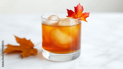 glass of golden maple bourbon smash cocktail with maple leaf garnish isolated on white background showing whiskey drink concept