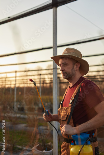Obraz na płótnie Farmer using pesticide, insecticide and herbicide sprayer sprinkler in an blueberries farm outdoors in springtime, before blooming. w salonie
