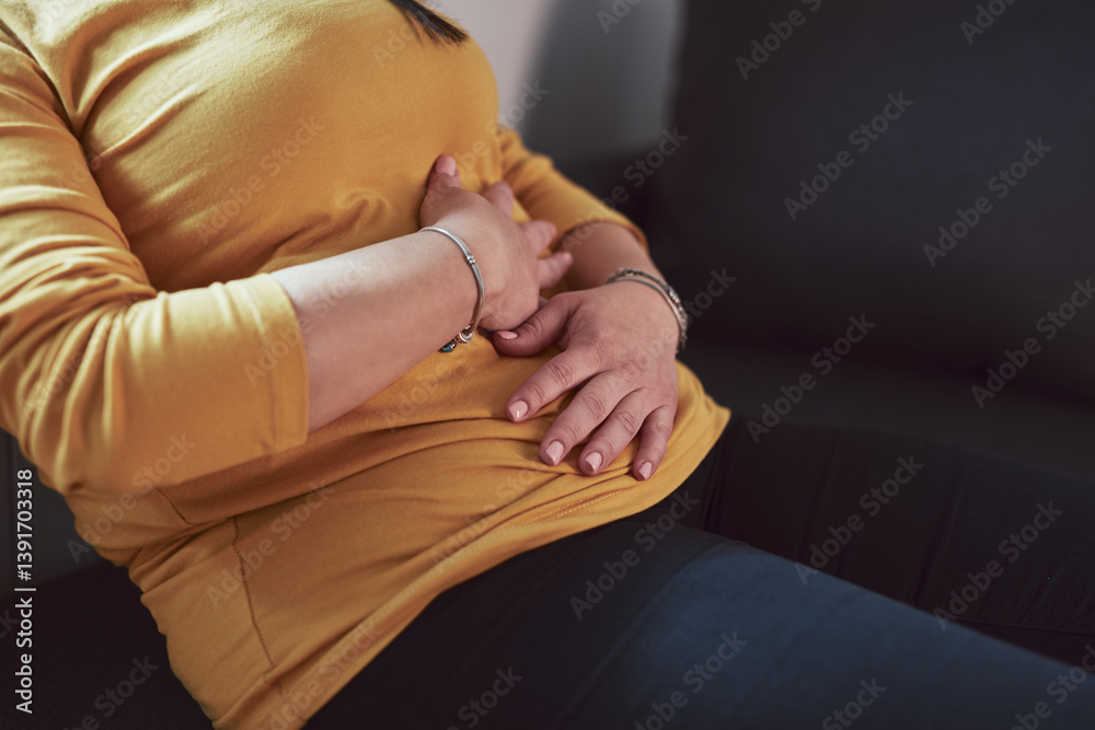 Woman with strong stomach ache, menstrual and digestive issues at home.