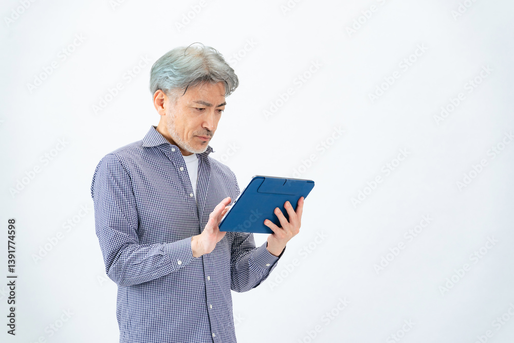 タブレットPCを使うシニア男性