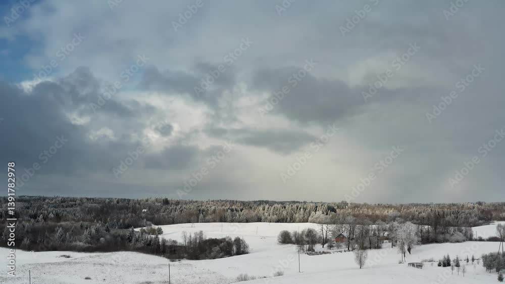 Stunning aerial drone view of snowy winter forest under a dramatic cloudy sky with sunlight breaking through. Winter scenery in countryside. Clean environment. Stunning aerial drone view of snowy winter forest under a dramatic cloudy sky with sunlight breaking through. Winter scenery in countryside. Clean environment.