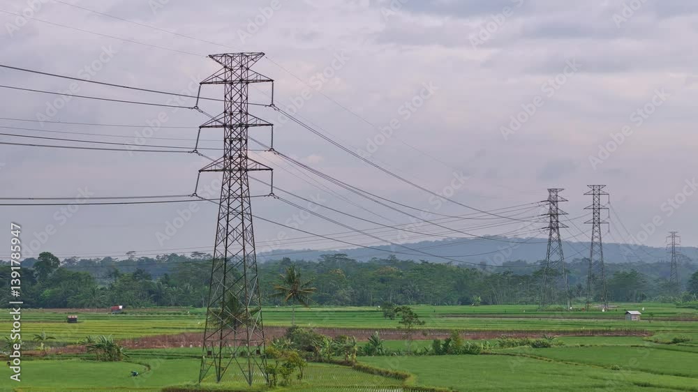 Established aerial shot electricity pylons with cloudy sky