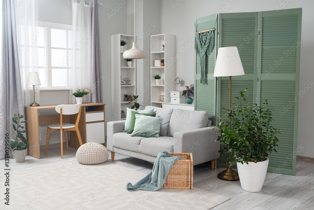 Fototapeta premium Interior of living room with green folding screen, sofa and plants
