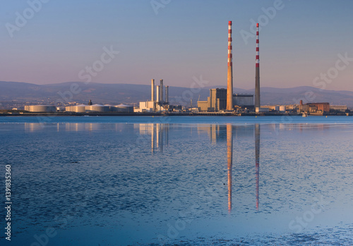 Photography poolbeg power station in dublin at  sunrise with reflection on the river liffey