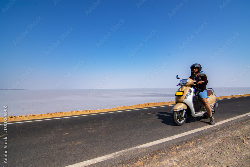 Female Solo Traveler Posing on Scooter at Road to Heaven in White Desert of Rann of Kutch