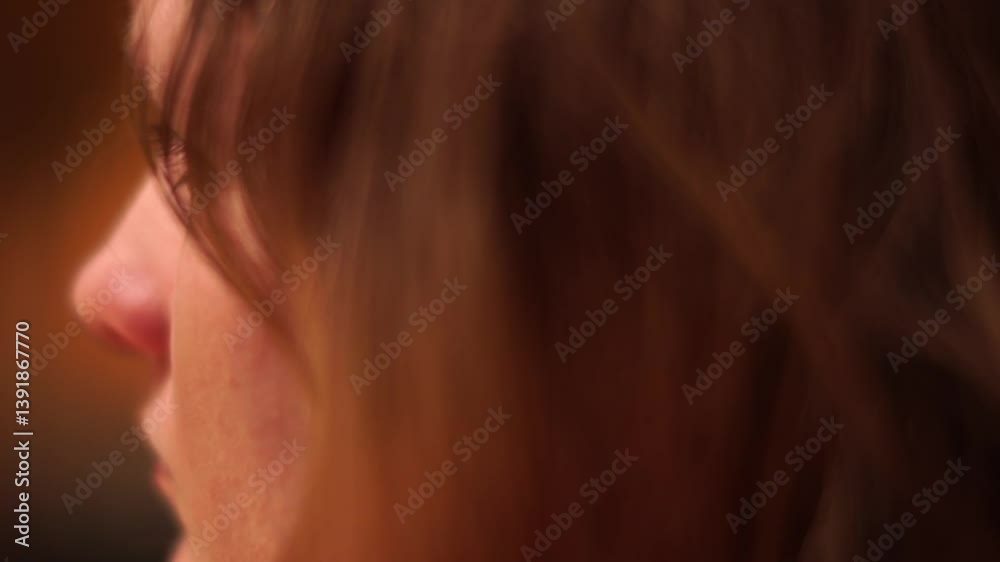 Abstract close-up of a person's side profile with soft focus and warm lighting, evoking intimacy and reflection.