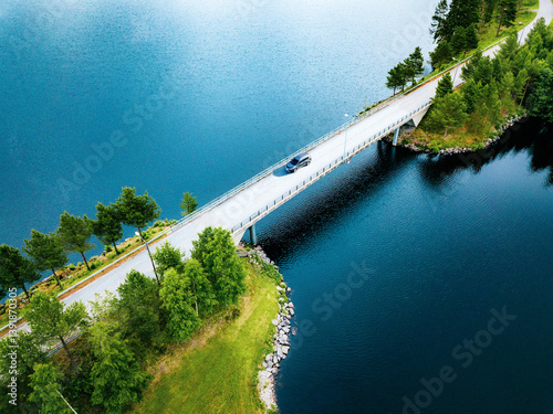 Obraz na płótnie Aerial view of bridge asphalt road with car driving over blue water lake in Finland w salonie