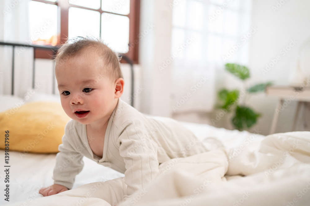 Innocent Asian cute newborn baby learning to crawl on bed in the bedroom. Innocent Asian cute newborn baby learning to crawl on bed in the bedroom.
