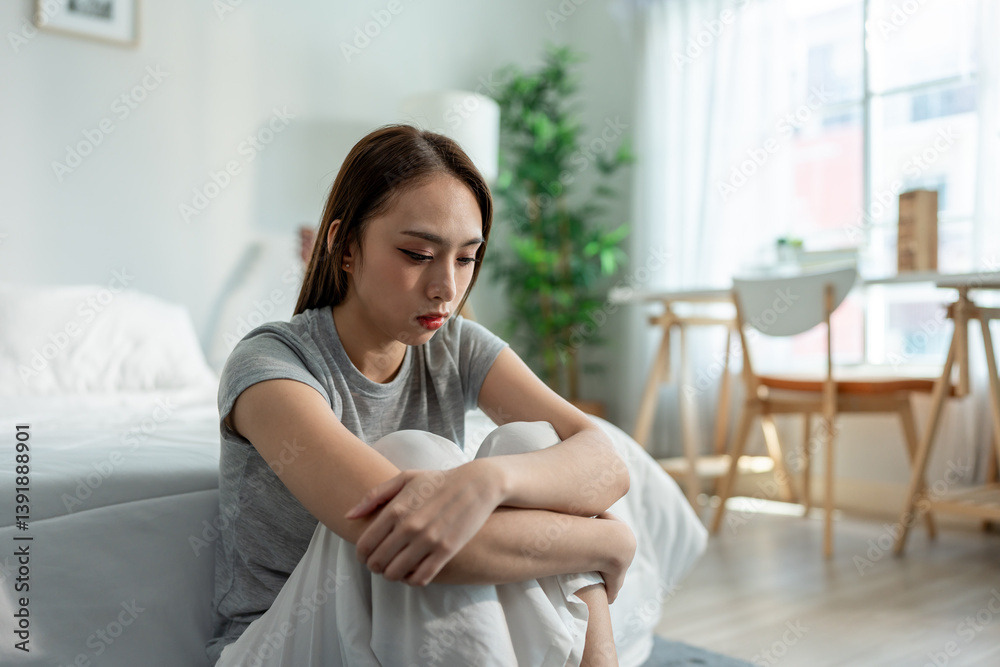 Depressed Asian woman feel upset while sitting alone on floor in bedroom. Depressed Asian woman feel upset while sitting alone on floor in bedroom.
