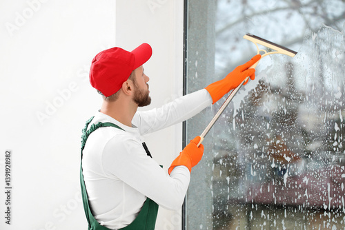 Male worker with squeegee w...
