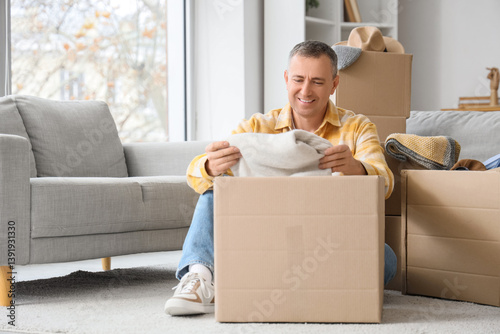 Mature man unpacking box wi...
