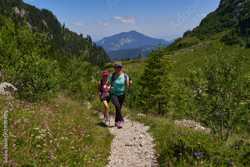 Women hiking toward forested mountain........4o..