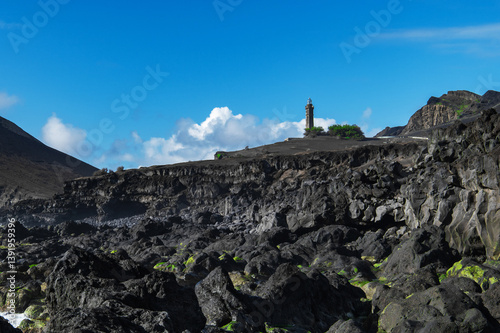 Farol da Ponta dos Capelinhos lighthouse at Faial island of the Azores, Portugal. Former beacon on the Atlantic Ocean coast. Eruption of Capelinhos volcano. photo