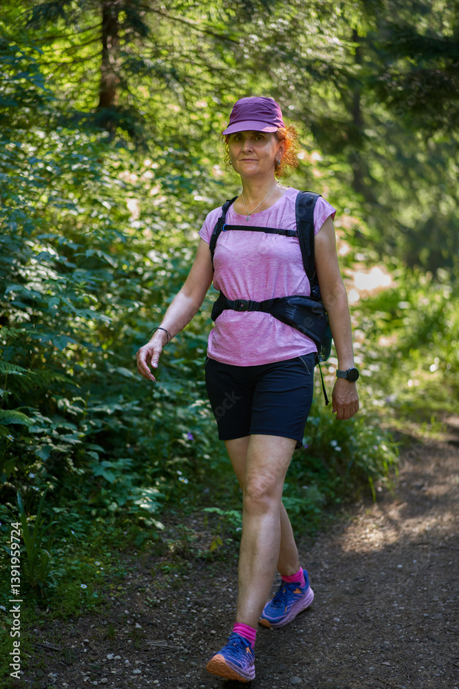 Woman hiking through sunlit forest......... Woman hiking through sunlit forest.........
