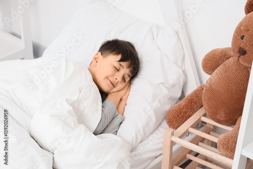 Cute boy sleeping on bed at home