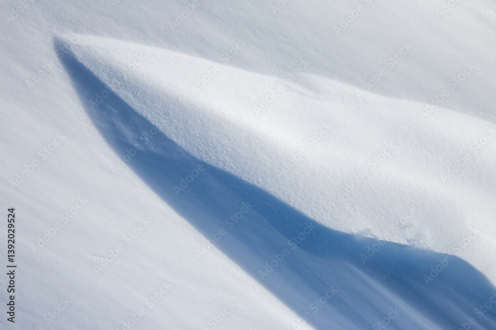 Beautiful winter background with snowy ground. Natural snow texture. Wind sculpted patterns on snow surface.