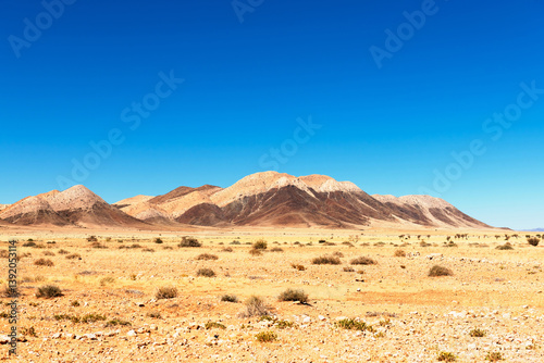 Typical lifeless landscape of Namibia, Africa. Sapless desert and mountains on clear blue sky background