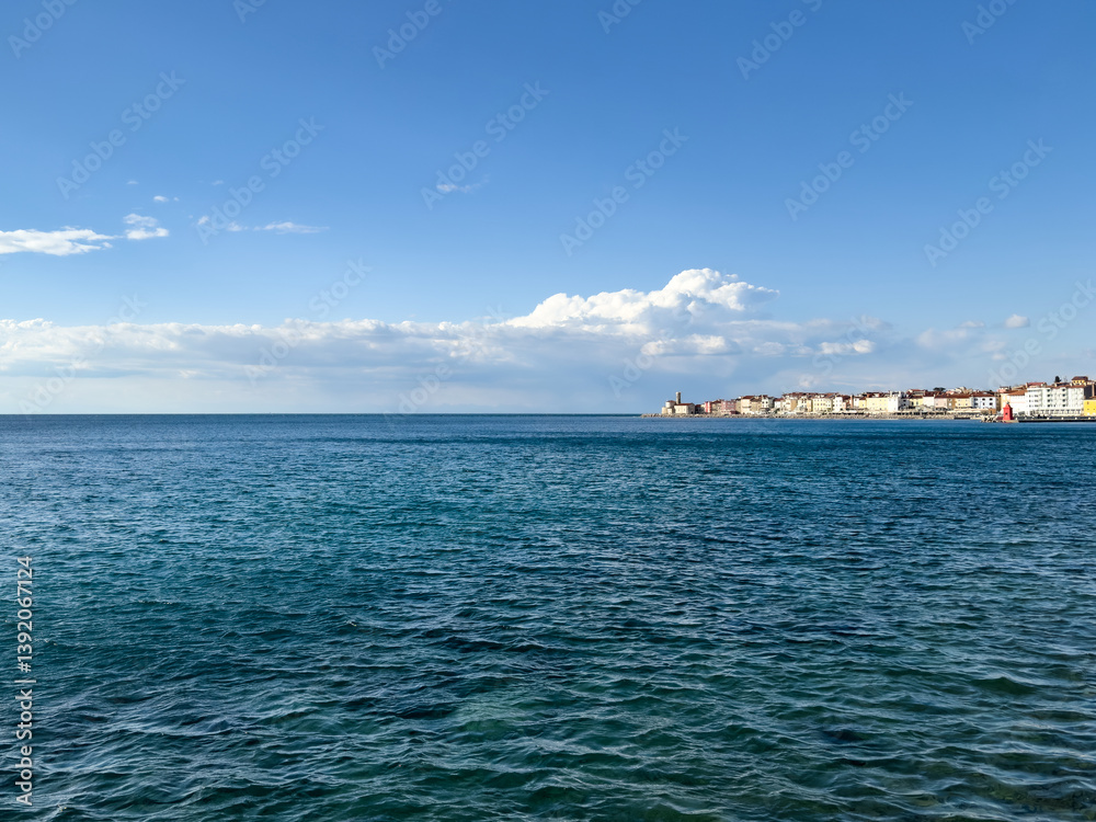 seascape with view of a small Mediterranean coastal town under blue sky with fluffy clouds. sea background. old Mediterranean town seascape with view of a small Mediterranean coastal town under blue sky with fluffy clouds. sea background. old Mediterranean town