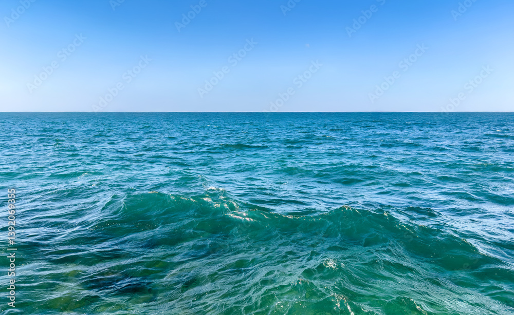 Obraz premium Close-up of calm emerald turquoise sea under clear blue sky on a sunny day. sea water surface. minimalist seascape