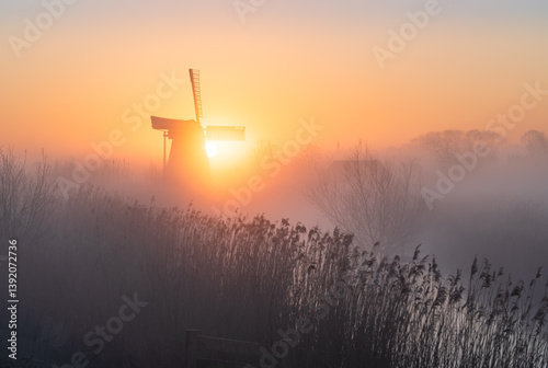Obraz na płótnie Dawn at a traditional, Dutch windmill in the spring fog. w salonie
