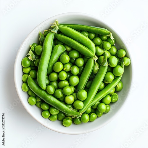 Overhead view of fresh green peas and pods in a white ceramic bowl dish