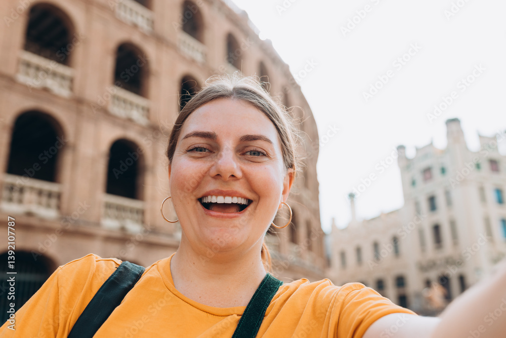 Beautiful 30s female walking in Valencia. Young traveling woman taking selfie outdoors. Concept of travel, tourism and vacation in city. High quality photo
