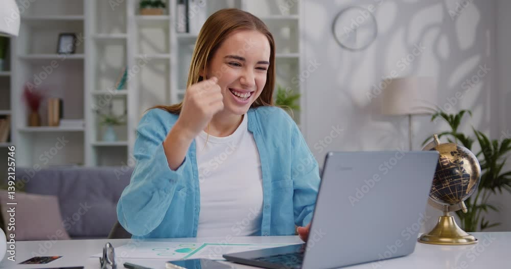 Woman working at laptop from home office. Girl looking at laptop screen reads good news in email having fun celebrating good news.