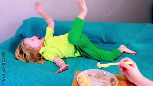 Child enjoys food while playing comfortably on a couch during a casual indoor setting