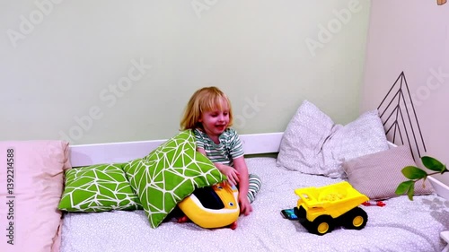 Little child enjoys playtime with bright toys and cushions in a cozy indoor space