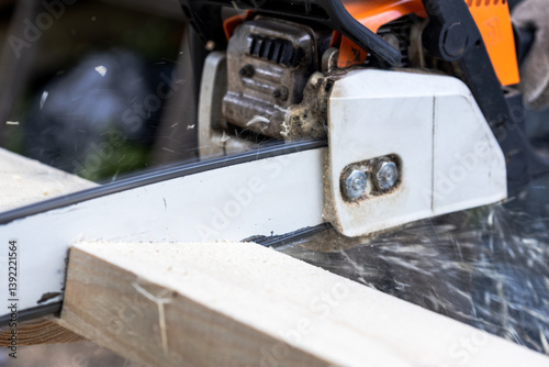 A chainsaw is cutting through a piece of wood