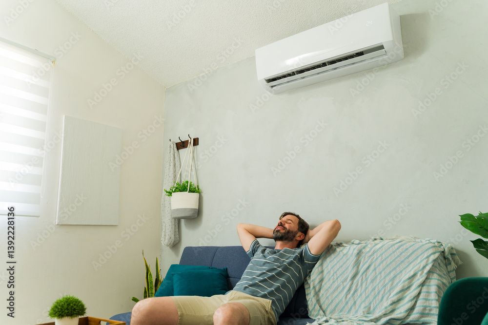 Man relaxing on sofa under air conditioning unit at home