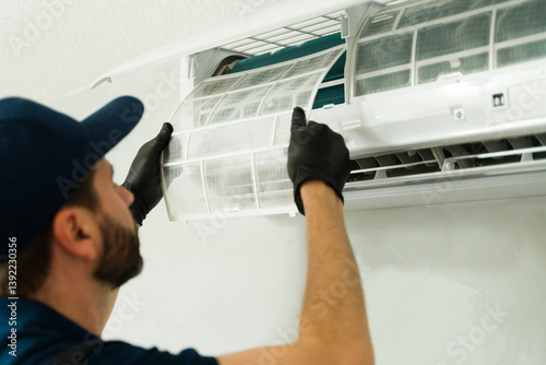 Closeup of a technician cleaning air conditioning filter during maintenance service