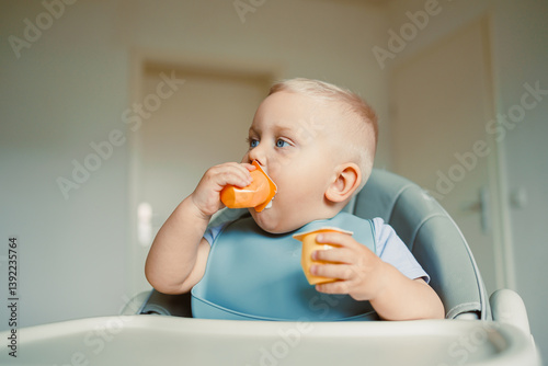 Obraz na płótnie Smiling boy sitting in a high chair, eating yogurt in the kitchen. Healthy food for children. Bio yogurt food for children. Children eating vegetables. Little boy eating dairy products. w salonie