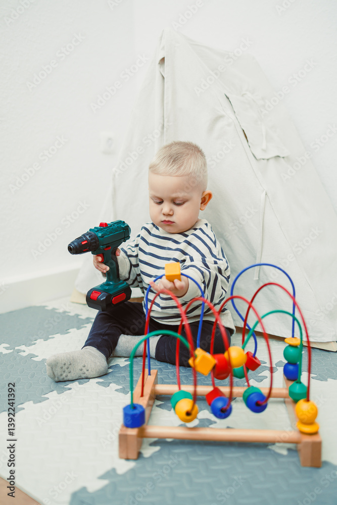 Toys for little children. Toddler boy playing with educational toy. Child playing with toy beads in kindergarten or nursery. Toddler child in nursery.