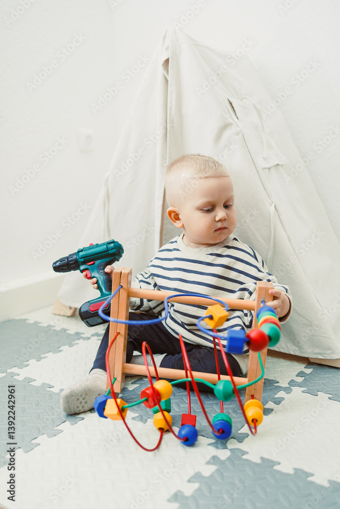 Toys for little children. Toddler boy playing with educational toy. Child playing with toy beads in kindergarten or nursery. Toddler child in nursery.