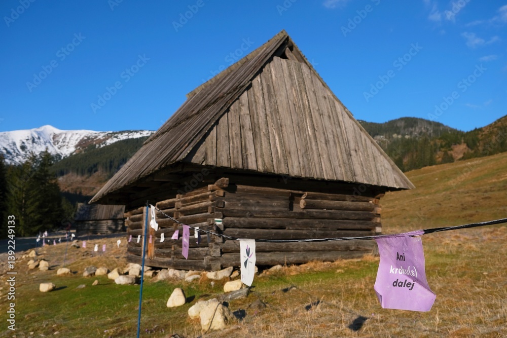 Shepherds' hut in Chochołowska Valley and string fence with note on card saying: Not step further. Tatra Mountains, Zakopane, Poland