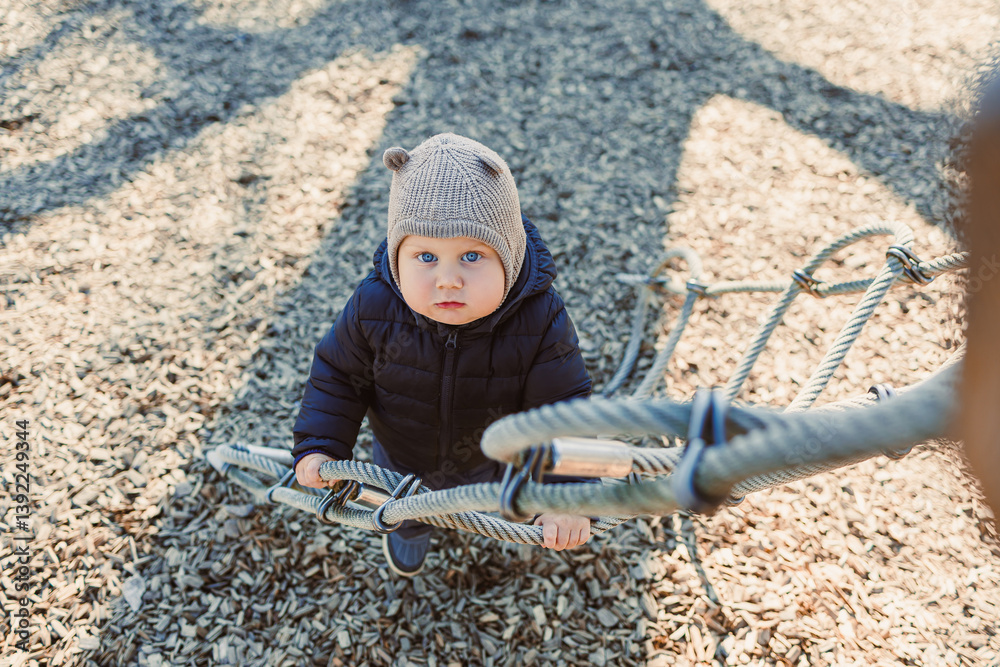 Happy toddler boy on a walk on the playground. Child development, healthy lifestyle of the child. Boy outdoors on an autumn walk.