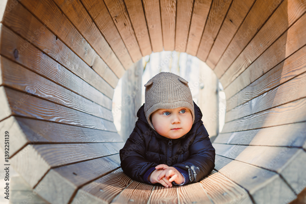 Child walking outdoors. Happy toddler boy on a walk on the playground. Child development, healthy lifestyle of the child. Boy outdoors on an autumn walk. Cheerful boy in the city park.