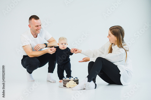 Obraz na płótnie A joyful family moment unfolds as loving parents play with their adorable toddler in a stylish studio, enriching their shared experience filled with love and happiness, creating beautiful memories w salonie