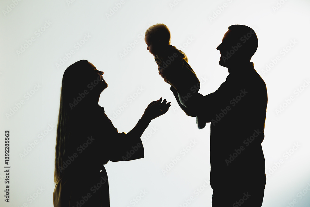 A Joyful Family Bonding Moment The Beautiful Silhouette of Loving Parents Celebrating and Sharing Laughter with Their Cherished Baby, Emphasizing Togetherness and Connection in Their Lives